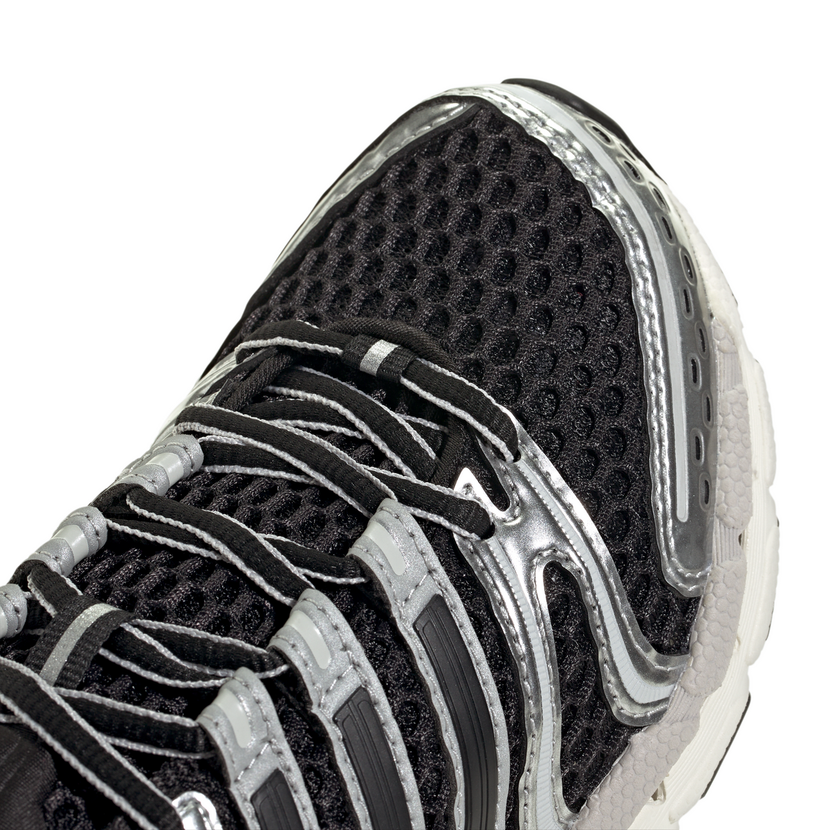 Black and silver Adidas Big Kids Adistar Control 5 grade school sneakers with detailed view of design and materials.