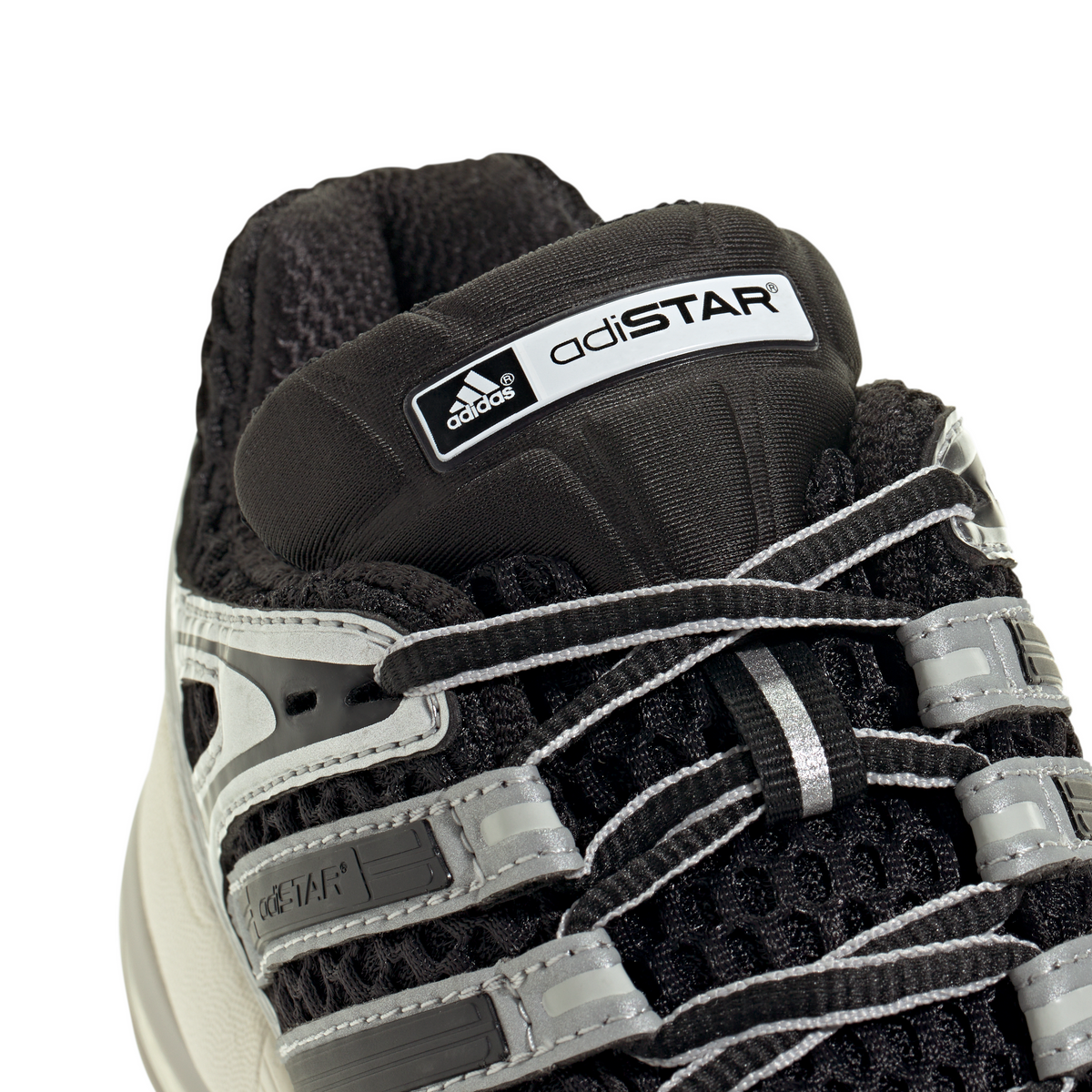 Black and silver Adidas Big Kids Adistar Control 5 gradeschool athletic shoes displayed with detailed view of the footwear.