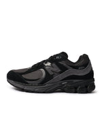 Black New Balance 2002R men's footwear shoes with stylish design, shown from a side angle.