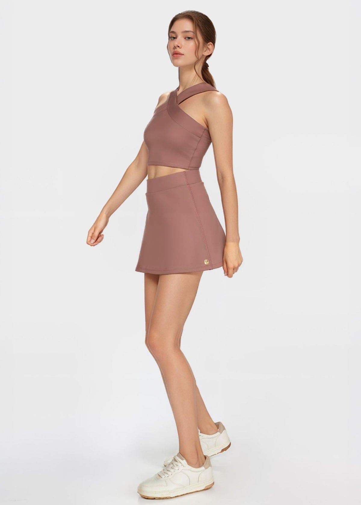 Trophy Yoga built-in pocket tennis skort in athletic fabric, worn by a player on the court, showcasing sporty design and functional pocket.