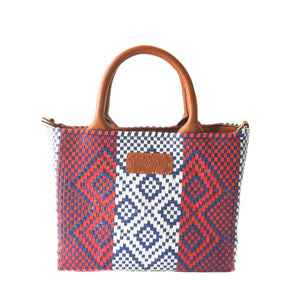 Small woven crossbody bag by Tin Marin Brand in camel color, featuring a compact design with woven texture.