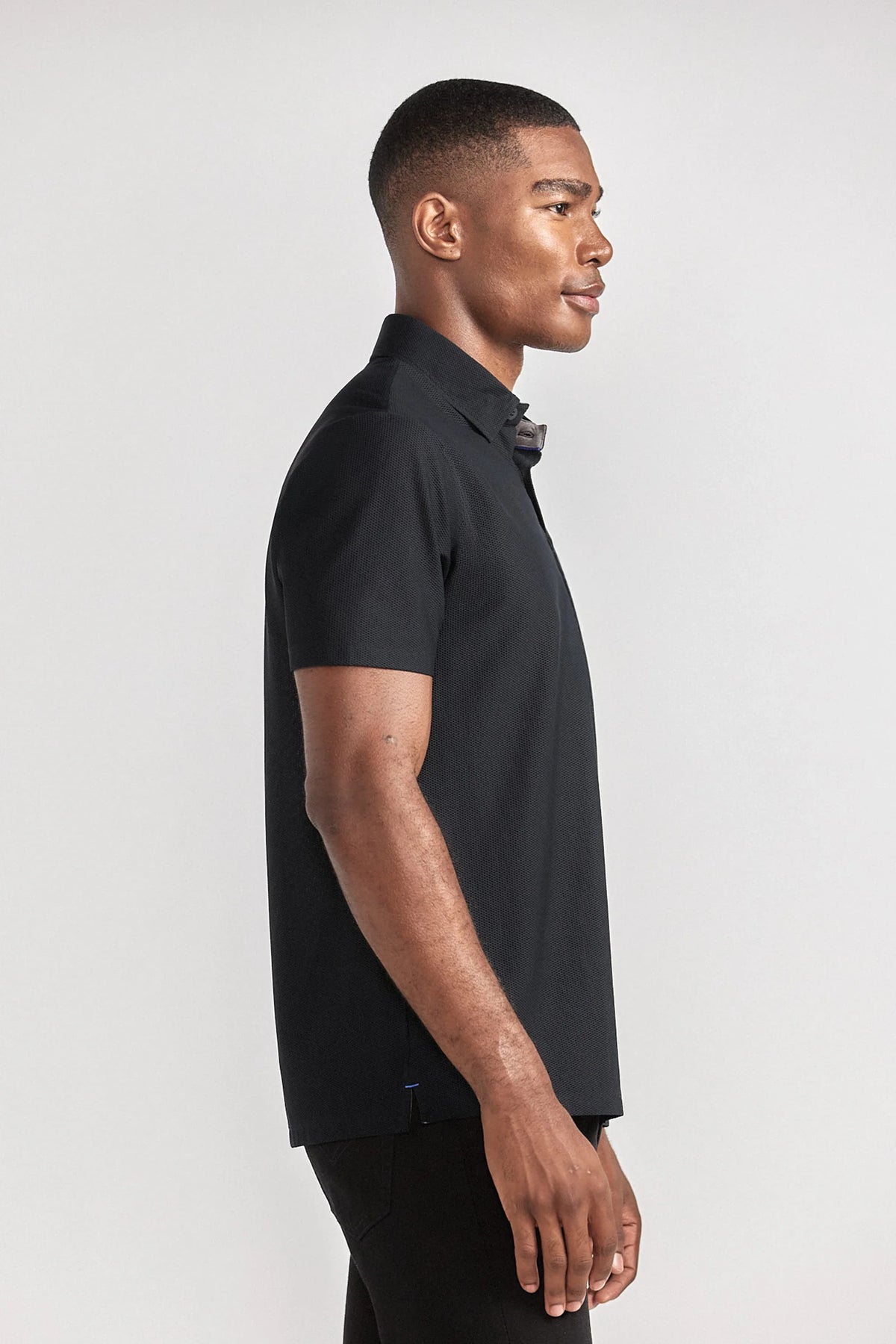 Black AIR 3 Button Polo by Twillory, casual short-sleeve shirt with a classic collar and three-button placket, shown from side view.
