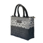 Black small woven crossbody bag by Tin Marin Brand with adjustable strap and textured woven design.