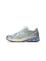 New Balance women's 1906 sneakers in metallic green with white accents, stylish footwear for women.
