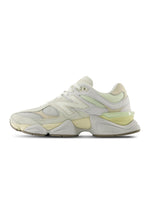 New Balance men's 9060 lifestyle shoes in white and yellow with sporty design and cushioned soles.