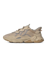 Brown Adidas Men's Ozweego sneakers showing side view with detailed design and textured sole.