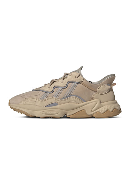 Brown Adidas Men's Ozweego sneakers showing side view with detailed design and textured sole.