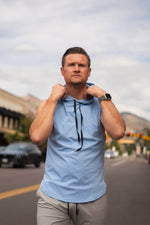 Ice blue Alyth Active DETERMINED hooded sleeveless clothing shown from the side view, highlighting its sleeveless design and sporty fit.
