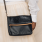Deux Mains black woven Foldover Clutch Crossbody bag close-up with adjustable strap
