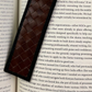 Brown woven Deux Mains bookmark displayed in a book