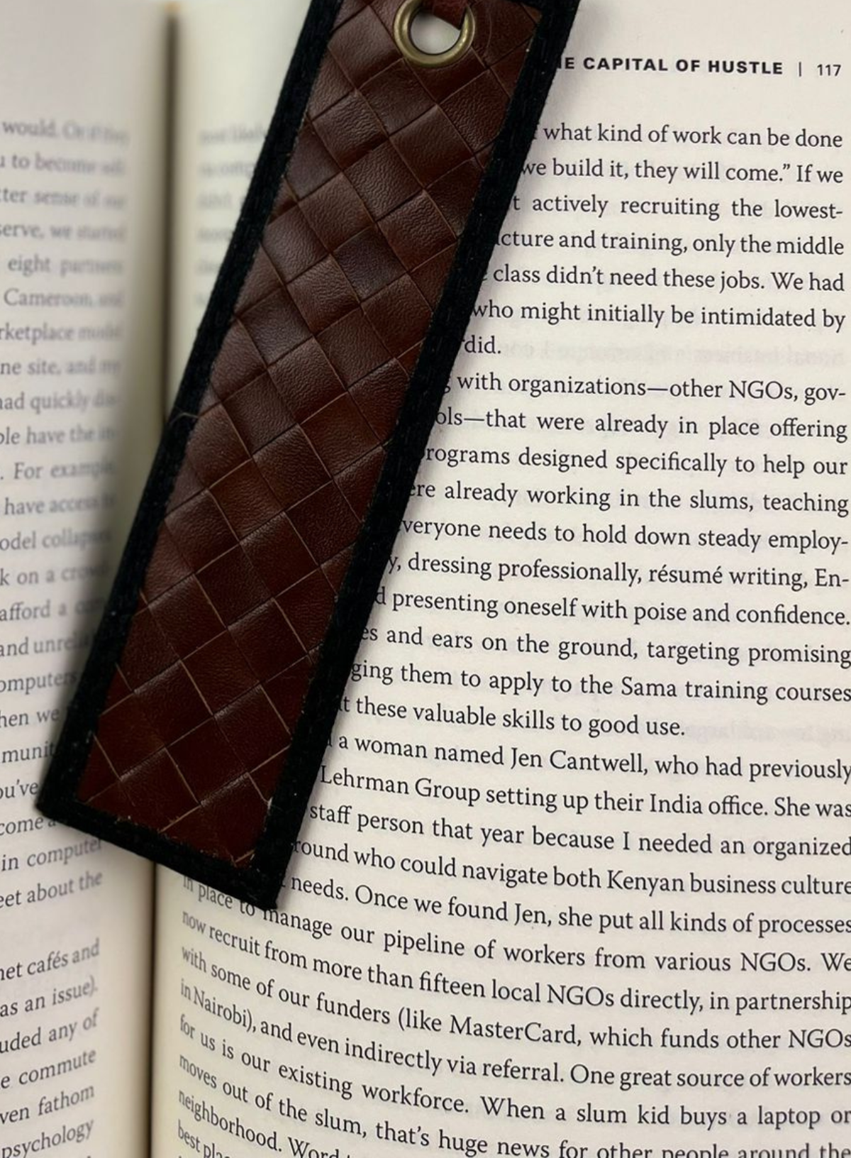 Brown woven Deux Mains bookmark displayed in a book
