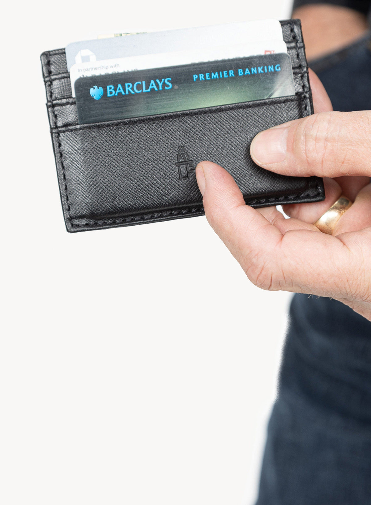 Deux Mains Call Signs card holder in black, front view held by model