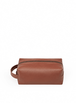 Deux Mains Iron Tight toiletry bag in cognac leather, front view with zip closure and compact rectangular design