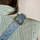 Baldwin Baby Company Ono Crossbody Belt Bag in blue, modeled as a diaper bag with adjustable strap