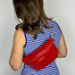 Baldwin Baby Company Ono Crossbody Belt Bag diaper bag in cardinal red, modeled from back