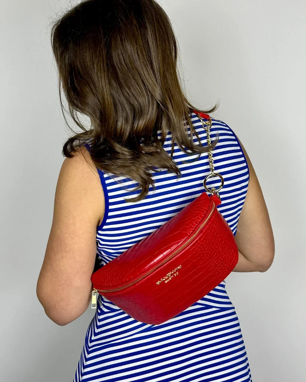 Baldwin Baby Company Ono Crossbody Belt Bag diaper bag in cardinal red, modeled from back