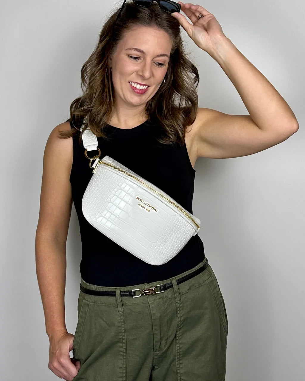 Baldwin Baby Company Ono Crossbody Belt Bag diaper bag in white, modeled from the front