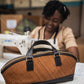 Deux Mains East-West handbag in a sleek horizontal design, crafted in a leather workshop setting