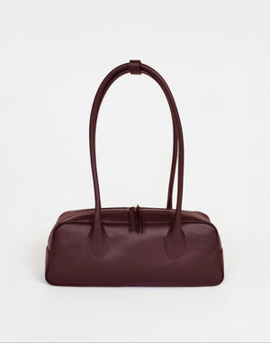 HYER GOODS La Strada East West Shoulder Bag in burgundy leather, featuring a sleek design with a top handle and adjustable strap.