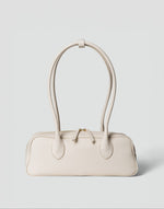 HYER GOODS La Strada East West shoulder bag in off-white leather with sleek design and minimal hardware.