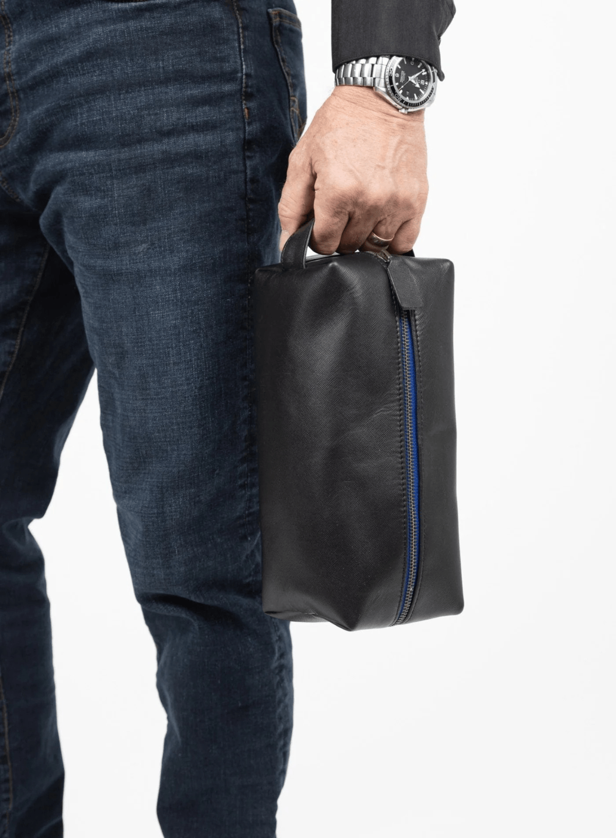Deux Mains Iron Tight toiletry bag in black and blue, held in hand