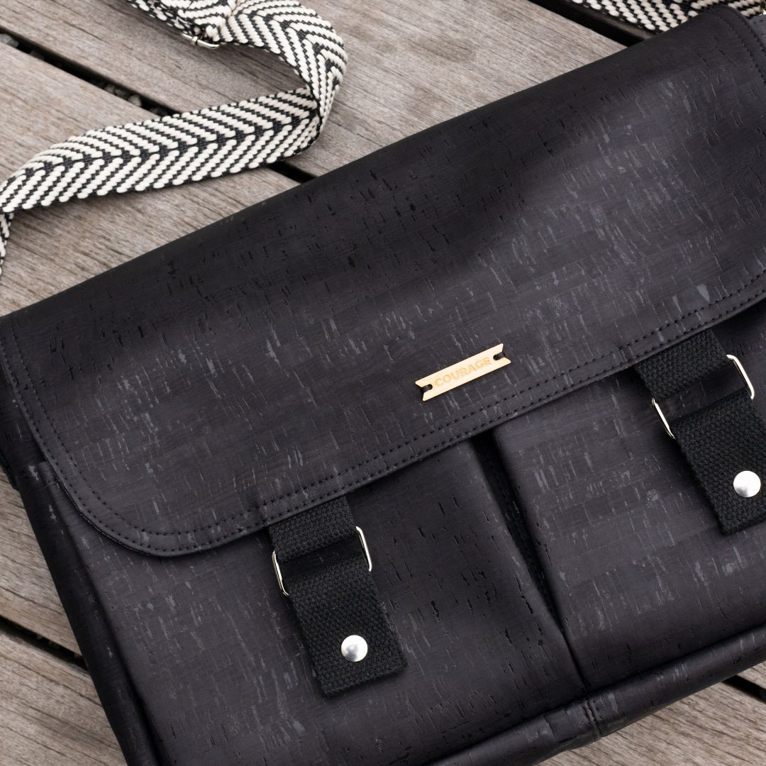 Carry Courage NOMAD messenger bag in coal black, showing compact crossbody design and adjustable strap