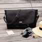 Carry Courage NOMAD messenger bag in coal gray with black strap, shown from the side
