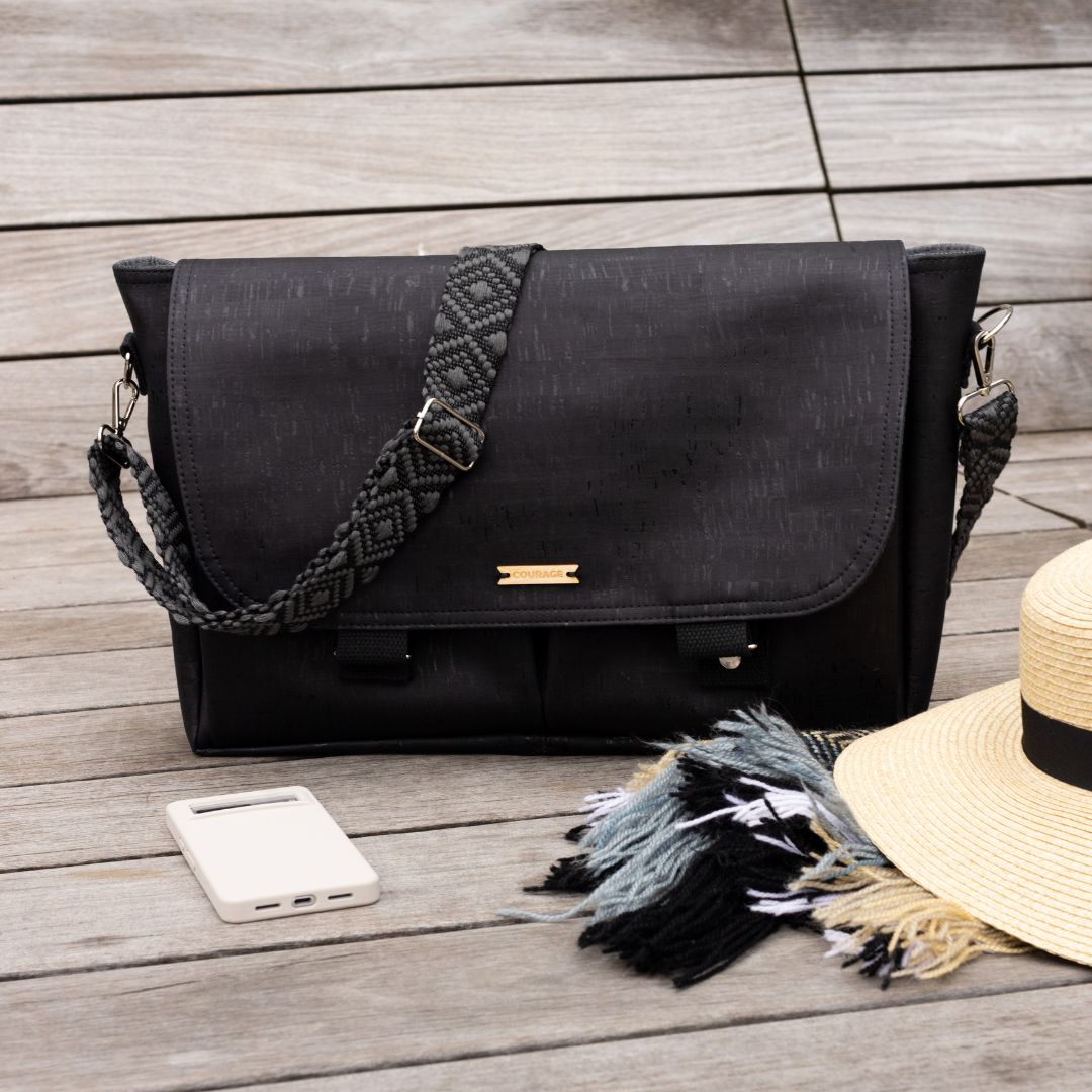 Carry Courage NOMAD messenger bag in coal gray with black strap, shown from the side