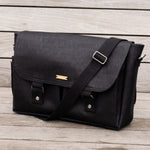 Carry Courage NOMAD messenger bag in coal with black-and-white strap detailing