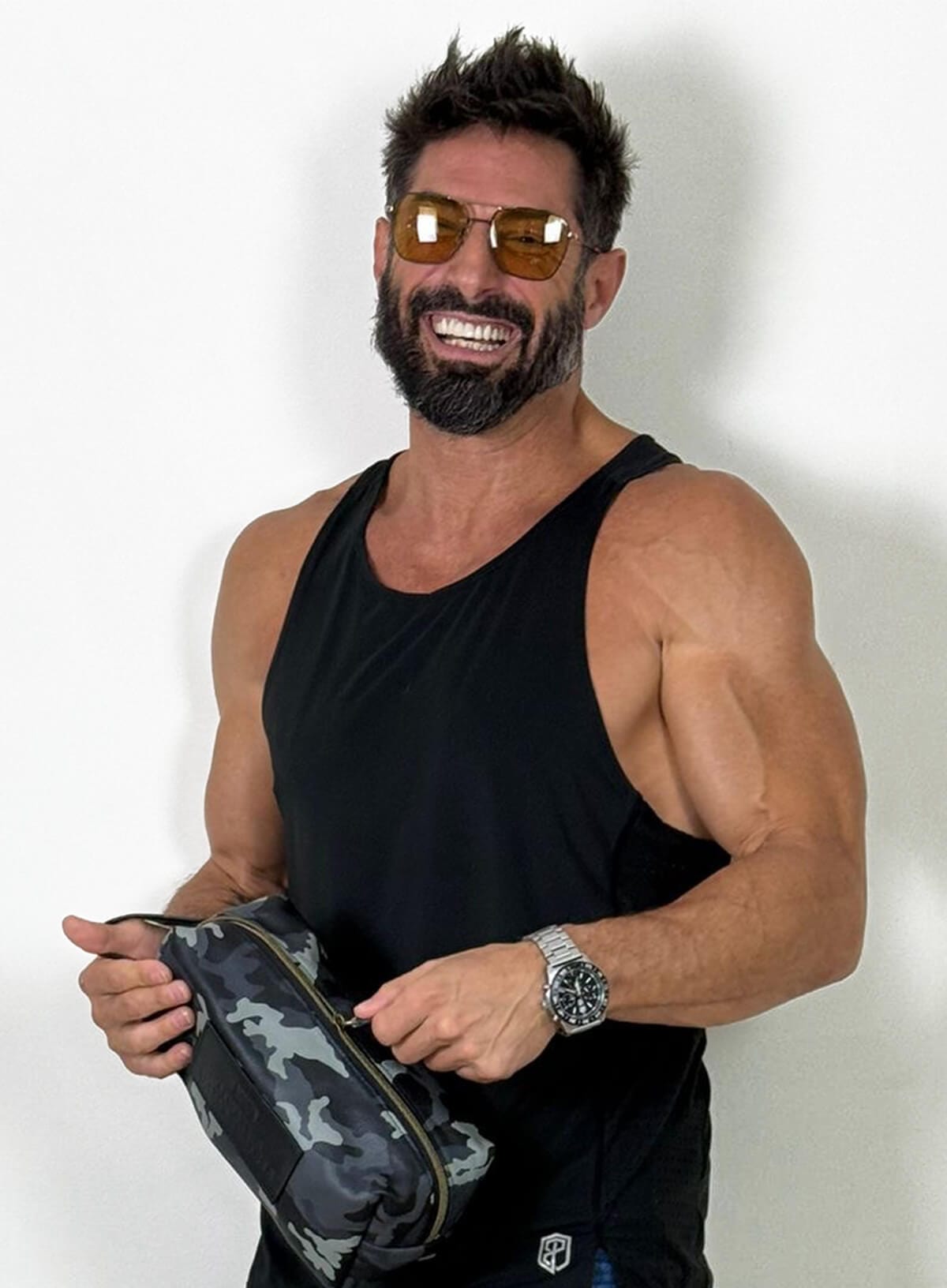 Deux Mains Iron Tight toiletry bag in cargo print, modeled by a laughing person