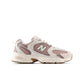 Beige and brown New Balance Women's 530 running shoes in a natural outdoor setting, showcasing sporty design and breathable material.