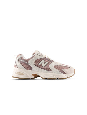 Beige and brown New Balance Women's 530 running shoes in a natural outdoor setting, showcasing sporty design and breathable material.