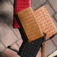 Deux Mains woven wristlet wallet displayed on a floor