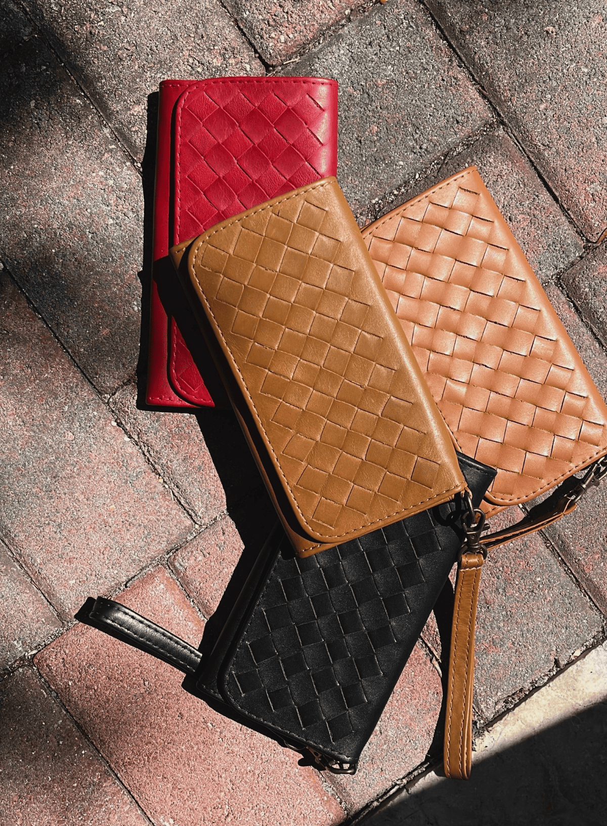 Deux Mains woven wristlet wallet displayed on a floor